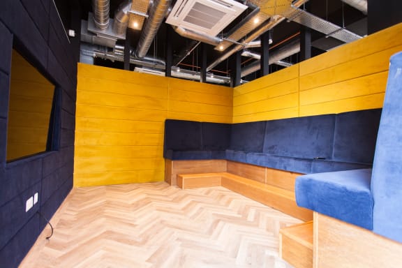 a room with a yellow wall and a blue couch
