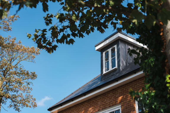 a red brick house with a window on the roof