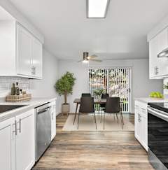 A kitchen with white cabinets and black appliances.