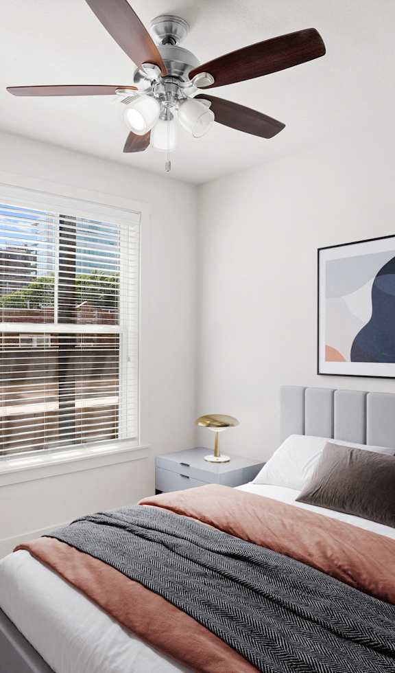 A bedroom with a ceiling fan, window and hardwood floors.