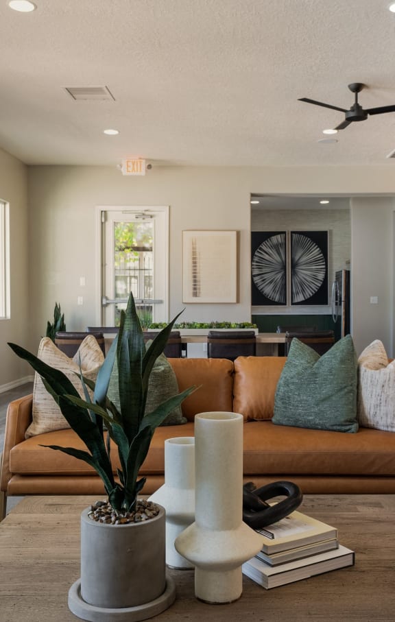 a living room with a couch and chairs and a ceiling fan