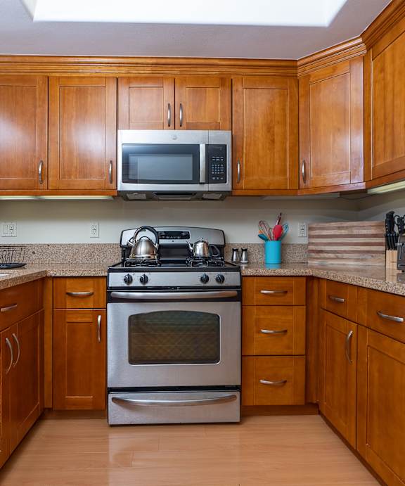 a kitchen with wood cabinets and stainless steel appliances