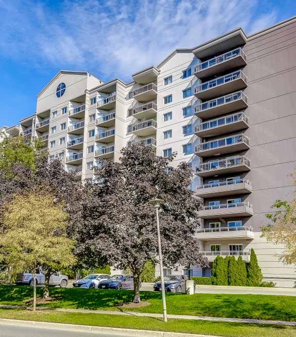 a large apartment building with balconies and trees in front of it