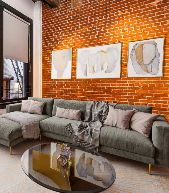 a living room with a couch and a table and a brick wall