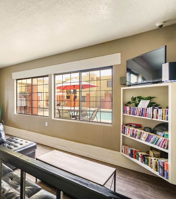 A living room with a black metal railing and a bookshelf filled with books.