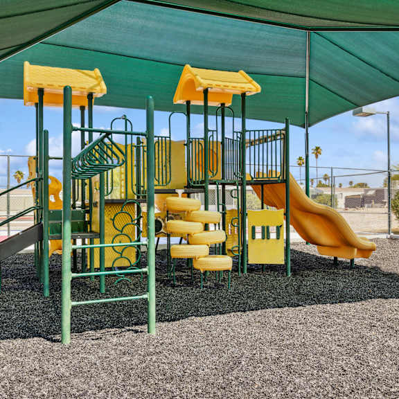A playground with a green and yellow slide.