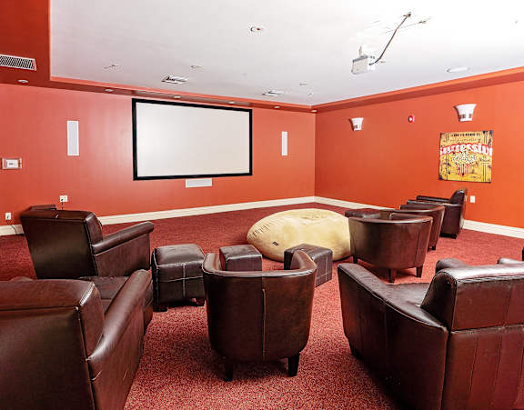 a room with leather chairs and a projector screen