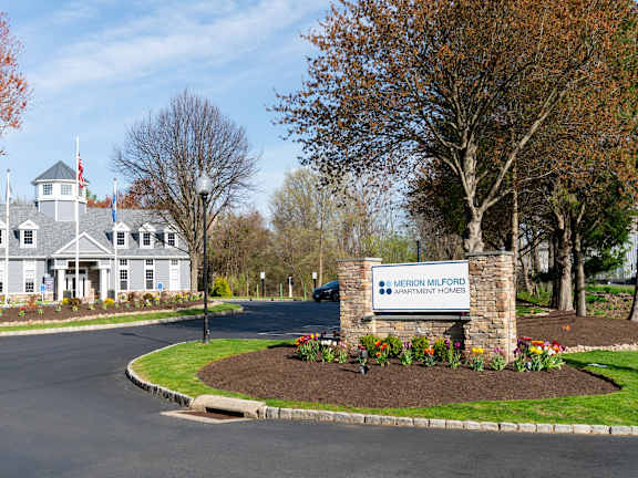 A sign for Merion Milford Apartment Homes is in front of a building.