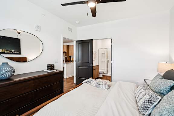 A bedroom with a large bed and a ceiling fan.