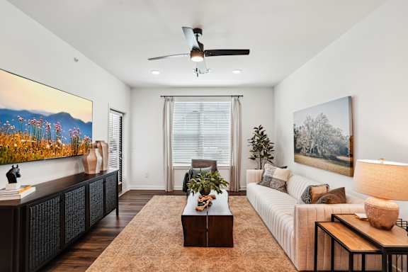 A living room with a brown rug and a white couch.