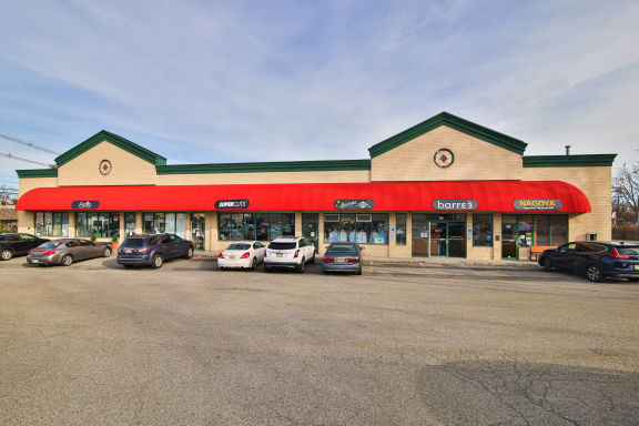 the front of a gas station with cars parked in a parking lot