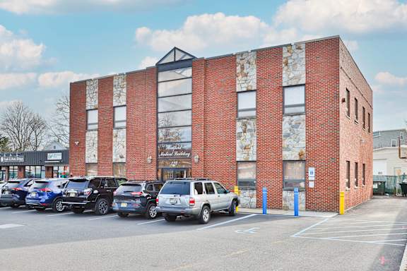 a brick building with a parking lot full of cars