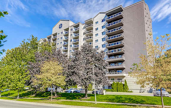 a large building with trees in front of it on a street