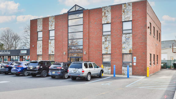 a brick building with a parking lot full of cars