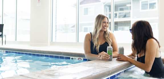 Two women are sitting in a hot tub and having a conversation.