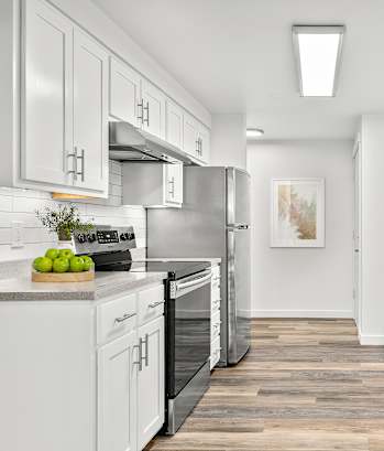 A modern kitchen with white cabinets and stainless steel appliances.
