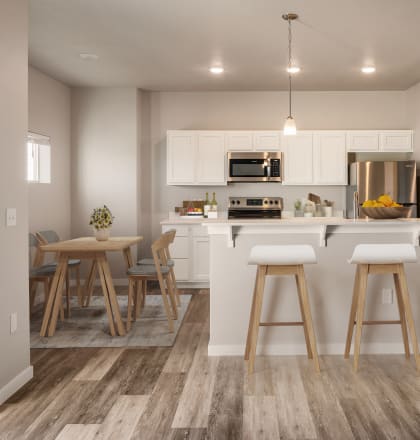 an open kitchen with a large island with bar stools at Southside Townhomes, Nampa, ID
