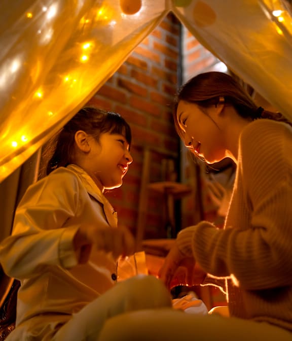 two girls sitting in a tent with lights at Waldo Heights, Kansas City, 64131