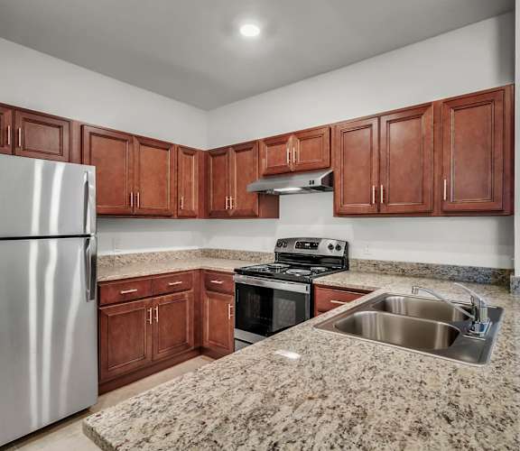 a kitchen with wooden cabinets and granite countertops