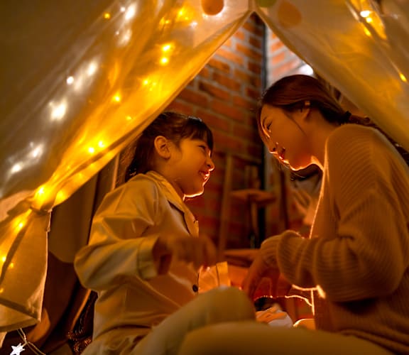 two girls sitting in a tent with lightsat Coach House Apartments, Missouri