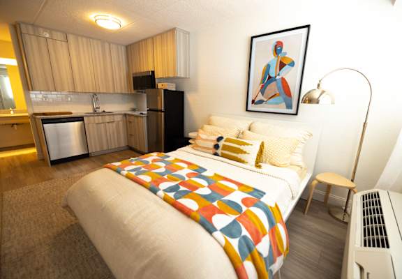 a bedroom with a bed and a kitchen in a small apartment at The Teale, Kissimmee, FL, 34746