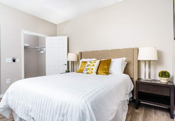 A bedroom with a white bed and a lamp on a side table at Missions at Chino Hills, Chino Hills