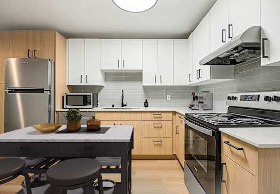 A modern kitchen with wooden cabinets and stainless steel appliances.