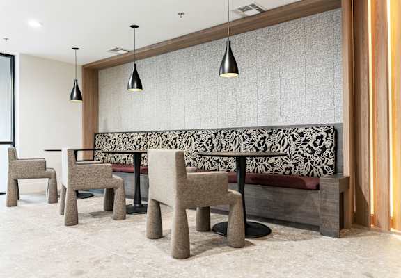 A row of chairs are lined up in front of a patterned bench.