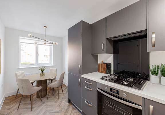 A modern kitchen with a dining table and chairs.