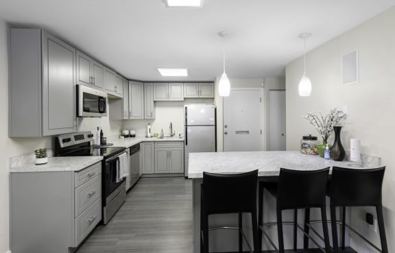 a kitchen with gray cabinets and a white counter top at Willows Court Apartment Homes, Seattle, Washington 98125