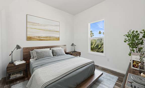 A bedroom with a large bed and a painting of a beach scene on the wall.