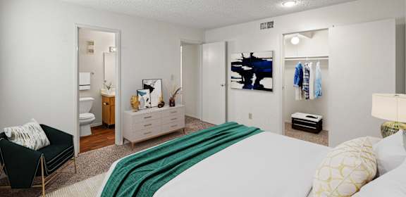 A bedroom with a bed, a couch, and a TV.