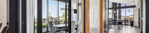 A modern office space with a view of the outdoors through large windows.