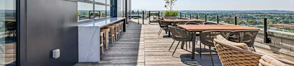A patio with a table and chairs overlooking a cityscape.
