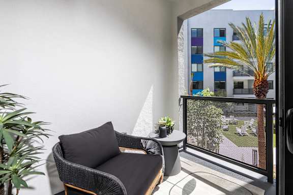 A balcony with a chair and a table.