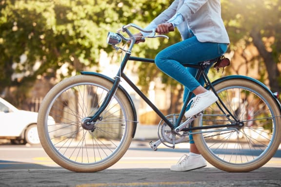 a woman riding a bike down a street at Mediterranean Village Costa Mesa, Costa Mesa, California