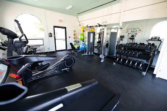 a gym with cardio equipment and weights on the floor at The Teale, Kissimmee, FL, 34746