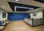 Thumbnail 3 of 14 - a lobby with a blue wall and a reception desk at 100 South Apartments, Buffalo, New York 14202