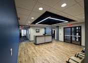 Thumbnail 2 of 14 - a large room with a desk and chairs in a lobby at 100 South Apartments, NY 14202