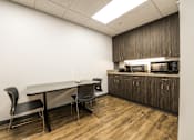 Thumbnail 9 of 14 - a room with a table and chairs and a counter with a microwave at 100 South Apartments, NY 14202