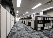 Thumbnail 8 of 14 - a library with rows of bookshelves and rows of cubicles at 100 South Apartments, Buffalo, 14202