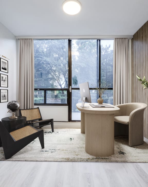 a living room with a desk and a large window