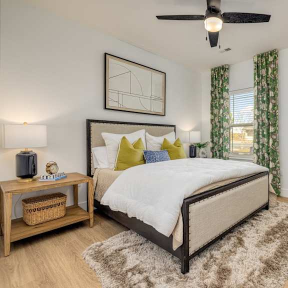 A bedroom with a large bed and a ceiling fan.