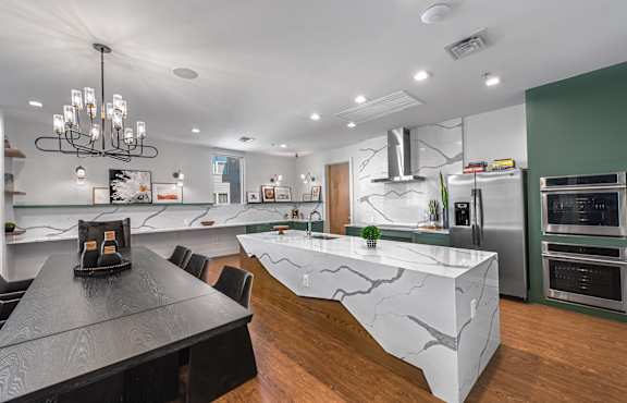 A modern kitchen with a black table and a marble island.