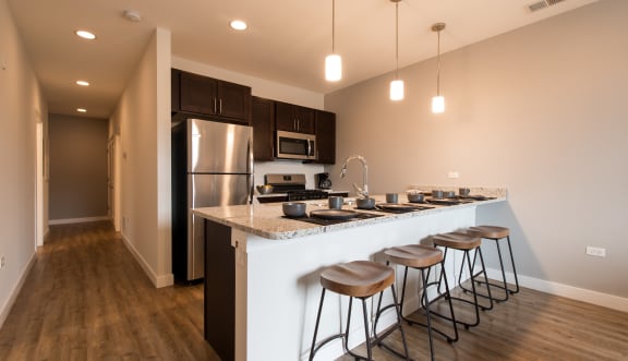 a kitchen with a large island with bar stools