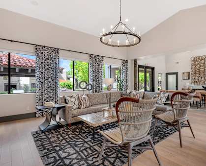 a living room with a couch and chairs and a dining table