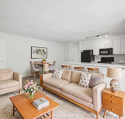 A living room with a couch, chairs, and a coffee table.