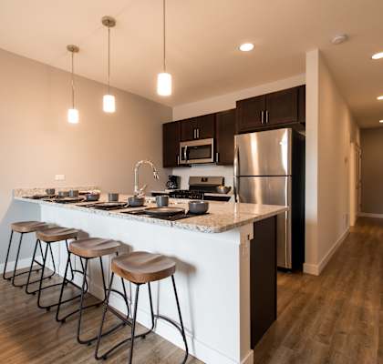 a kitchen with a large island with four stools