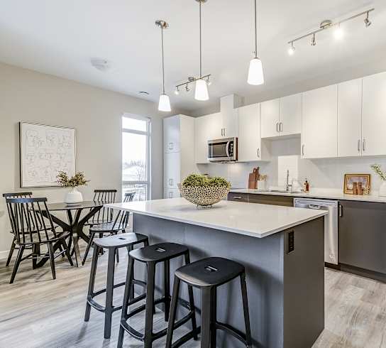an open kitchen and dining area with a large island and stainless steel refrigerator  at 101 Base Line Road West, London, ON