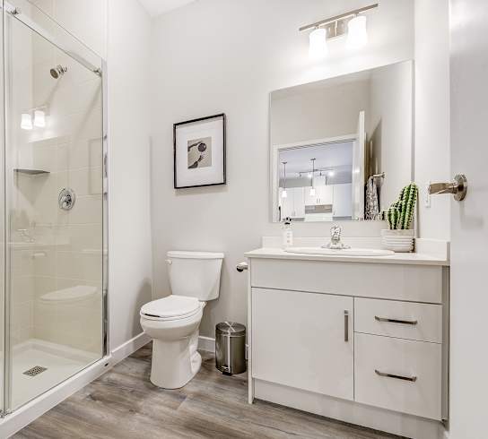 a white bathroom with a shower toilet and sink  at 101 Base Line Road West, London, ON